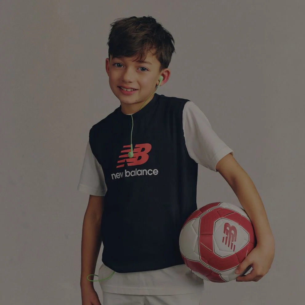 A child wearing a New Balance graphic tee.