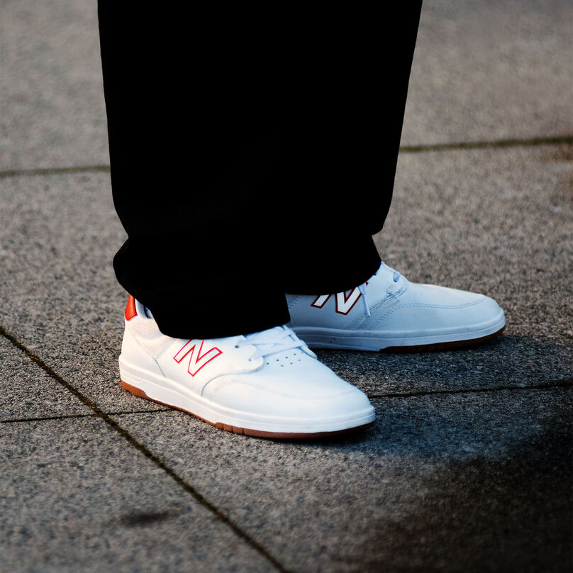 Person wearing 425 shoes in white with red details