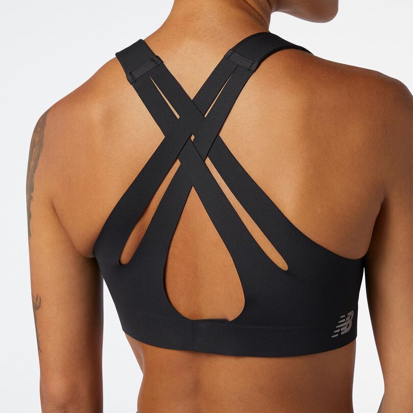 Woman turned from camera showing the back closure/fit of a black NB Fortiflow bra.