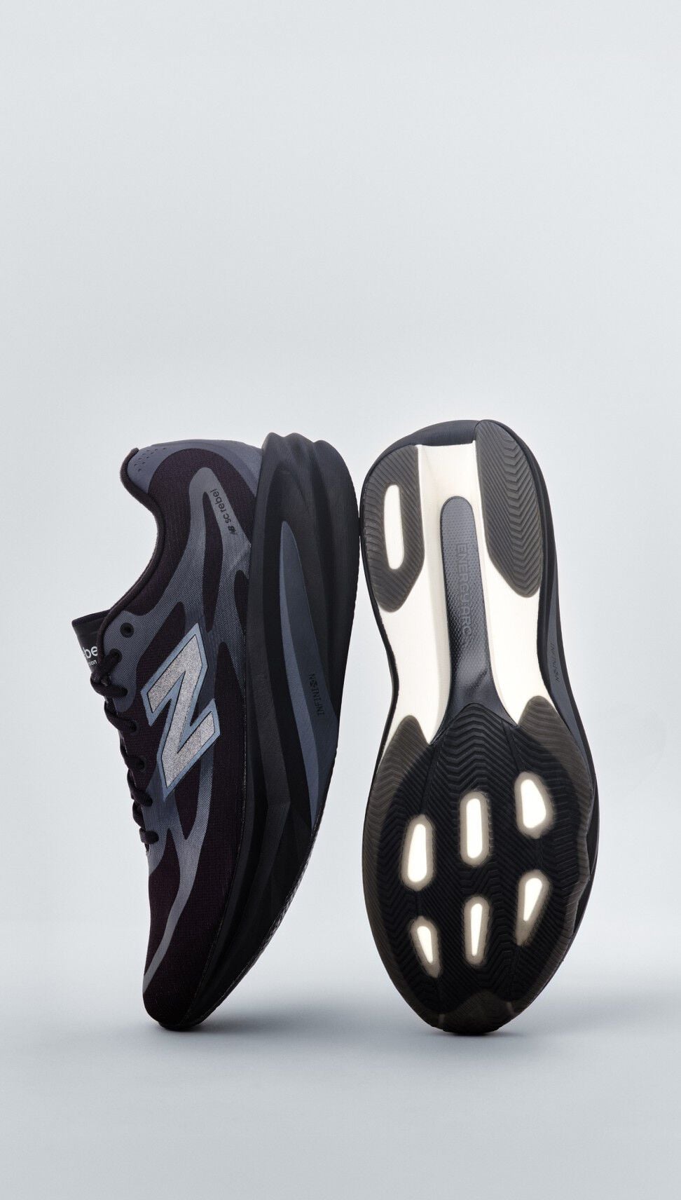 Une paire d'espadrilles New Balance noires pos&eacute;es sur un fond de studio gris.&nbsp;