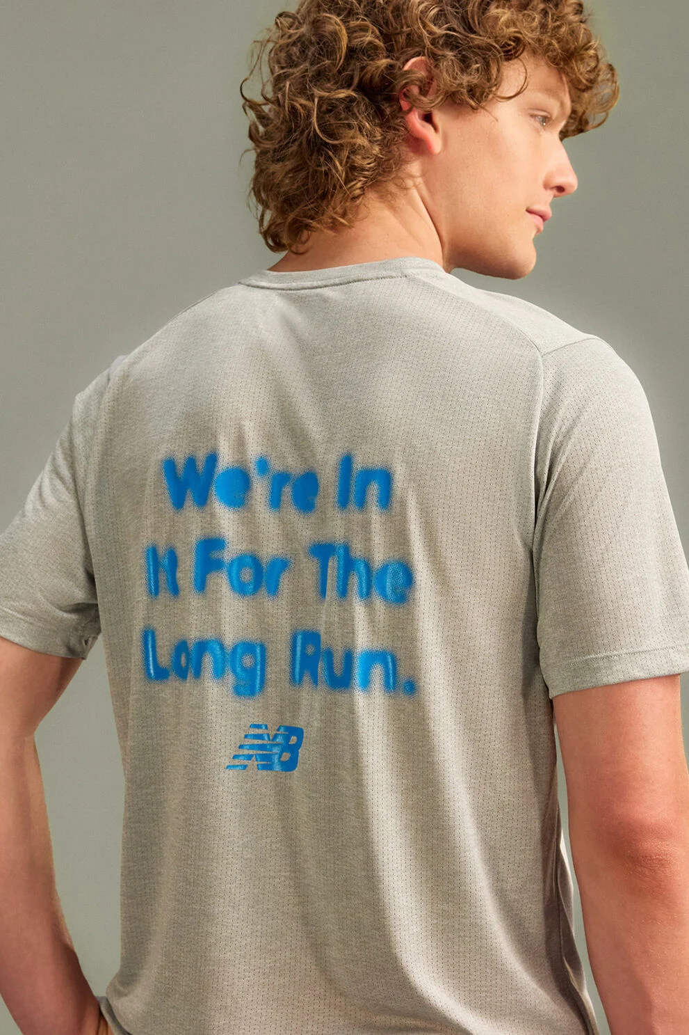 The person is wearing a light gray, short-sleeve athletic T-shirt with breathable mesh texture. 