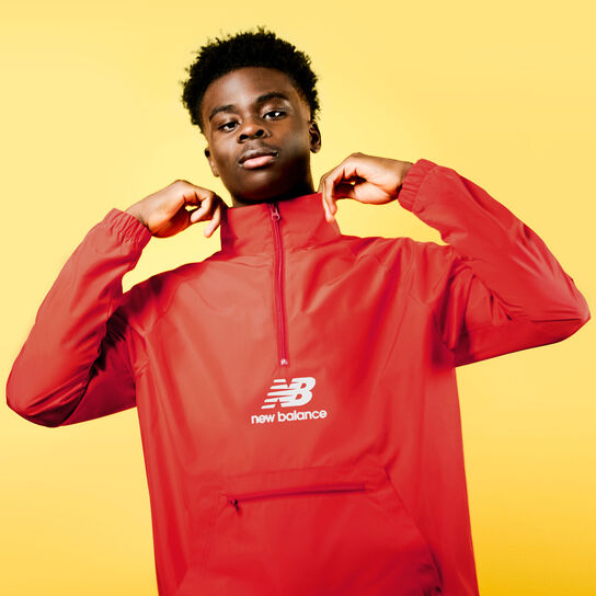 Bukayo Saka posed in red New Balance jacket.